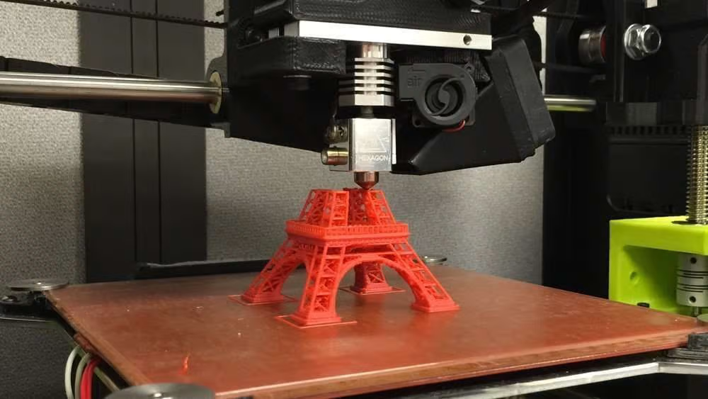 Printer 3D nggawe model Menara Eiffel kanthi materi abang Printer 3D nggawe model Menara Eiffel kanthi materi abang