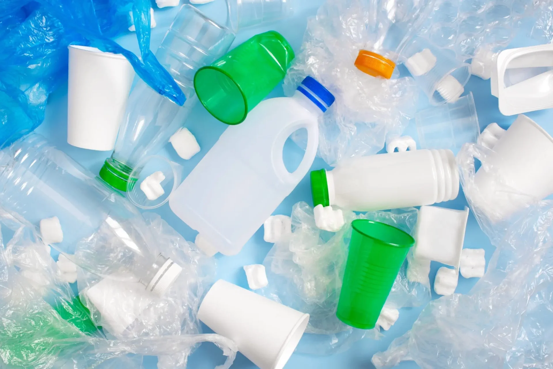 Verschiedene Plastikflaschen, Becher und Behälter zeigen wiederverwertbare Kunststoffe, die beim Spritzgießen von Textilien verwendet werden. Verschiedene Plastikflaschen, Becher und Behälter zeigen wiederverwertbare Kunststoffe, die beim Spritzgießen von Textilien verwendet werden.