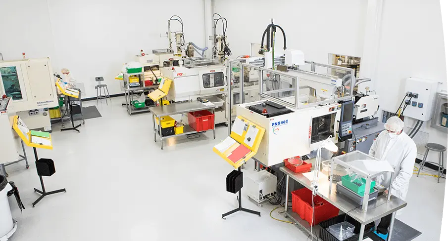 Cleanroom environment with multiple injection molding machines and technicians in protective clothing