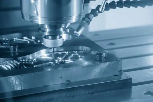 Close up of a CNC Computer Numerical Control machine in operation precisely cutting a piece of metal