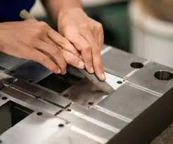Polishing a mold with precision tools to ensure smooth surfaces for manufacturing