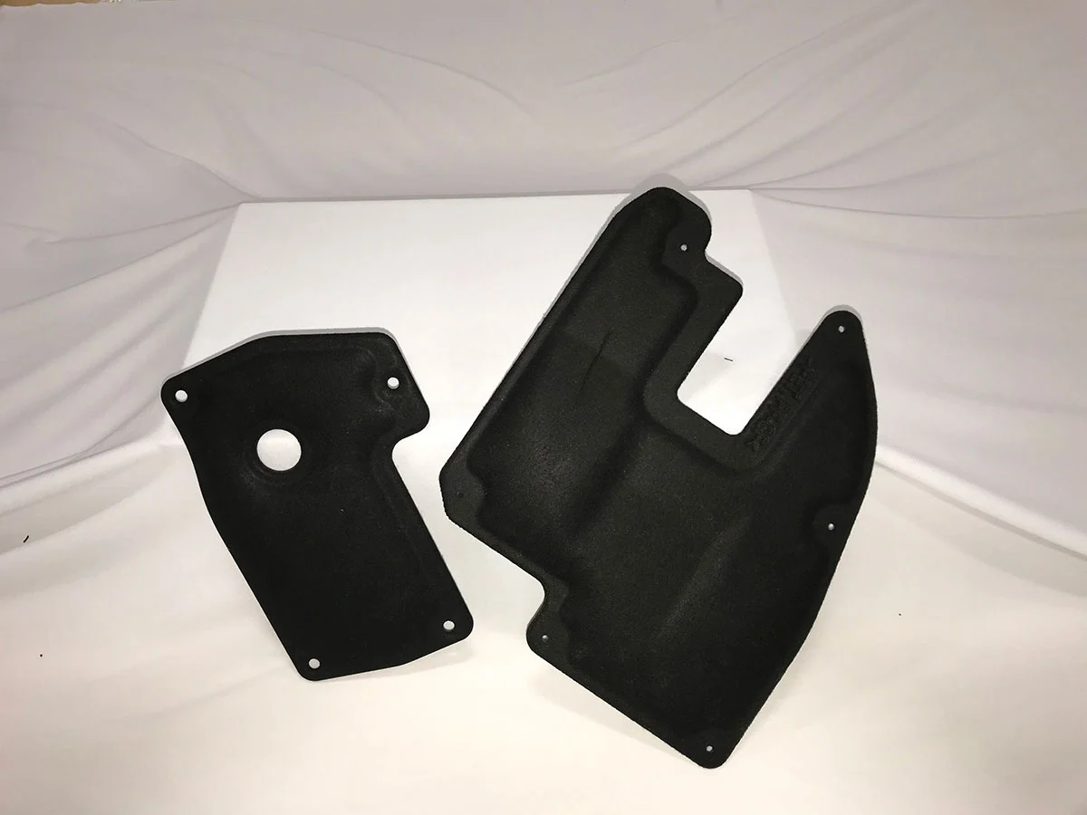 Two black automotive parts produced using compression molding Two black automotive parts produced using compression molding
